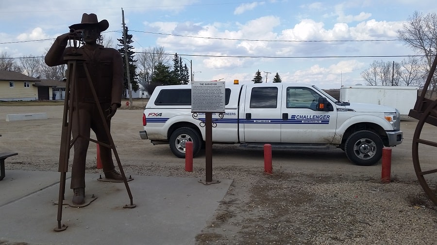The surveyor statue and plaque in front of challenger truck chamberlain saskatchewan