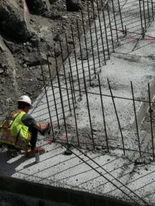 Surveyor marking rebar foundation layout on concrete footing at Park & Maven mixed-use development in Mission BC, using total station for construction survey, residential condo and commercial building site, Challenger Geomatics fieldwork, surveyor marking, rebar foundation layout, concrete footing, construction survey, total station, mixed-use development, residential condo, Surrey British Columbia, Surrey BC Surveyor, British Columbia Land Surveyor